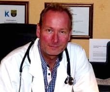 Ola Madsen at his desk in a white coat with a stethoscope