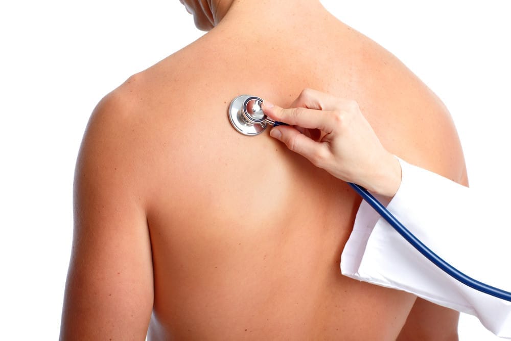 A stethoscope on a patient’s back during an examination