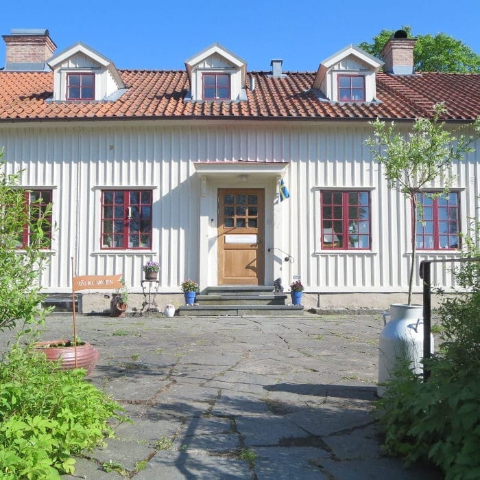 The rectory entrance in Vallda with a stone courtyard and red windows